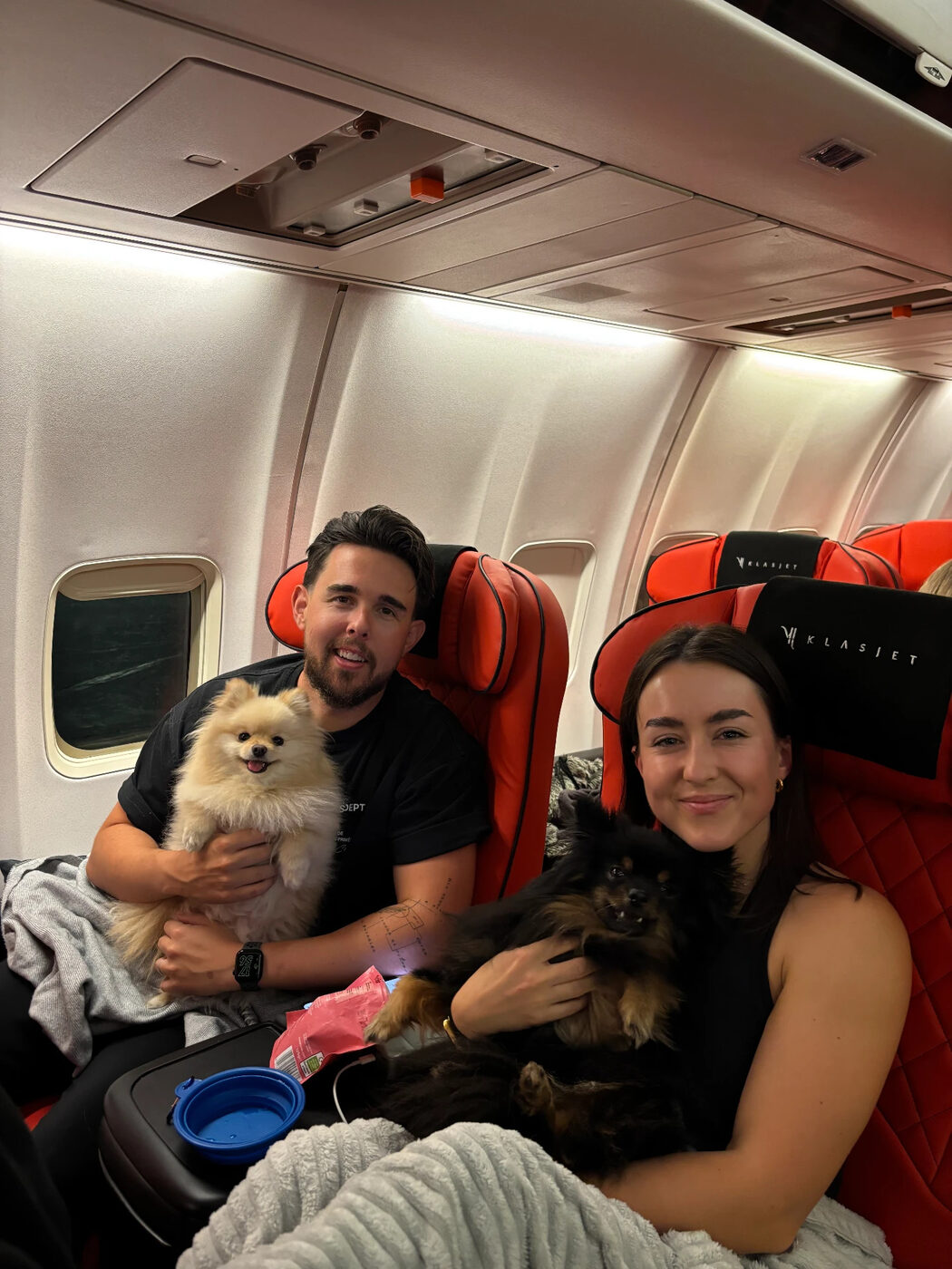 Couple onboard holding their two Pomeranians
